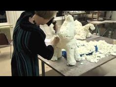 a woman is working on a sculpture in a studio