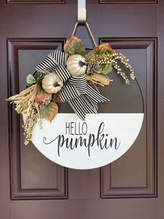 a door hanger that says hello pumpkin on it and is decorated with fall leaves