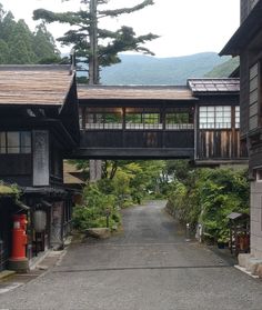 an alley way with buildings and trees on both sides that lead to the top of the hill