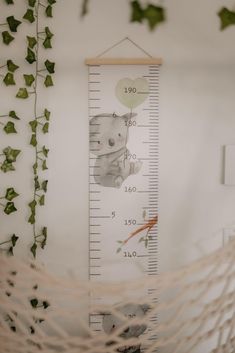 a growth chart is hanging on the wall next to ivys and other greenery