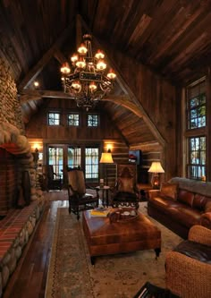 a living room filled with lots of furniture and a fire place under a chandelier