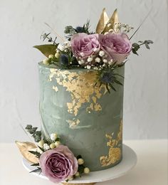 a green and gold cake with flowers on top