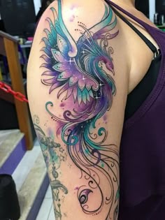 a woman's arm with tattoos on it and an artistic bird in the middle