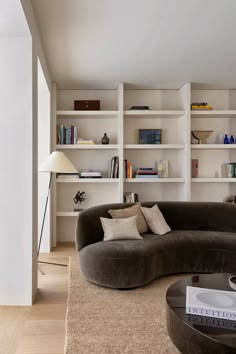 a living room filled with furniture and bookshelves next to a wall mounted book shelf