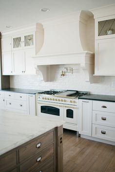 a kitchen with white cabinets and an oven