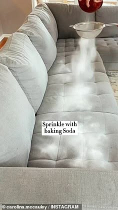 a person is pouring water into a bowl on top of a couch with the caption sprinkle - with baking soda