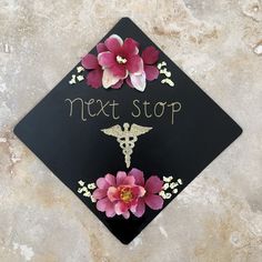 a black graduation cap with flowers and a stethoscope on it that says next stop