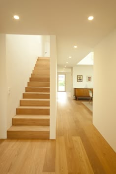 an empty room with wooden floors and white walls