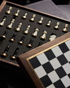 a chess board with pieces in it sitting on top of a table next to a black and white checkerboard