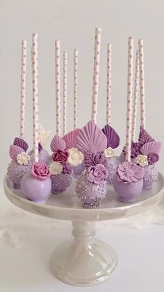 there is a cake that has candles in the shape of flowers and seashells on it