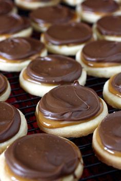 chocolate frosted cookies sitting on top of a cooling rack