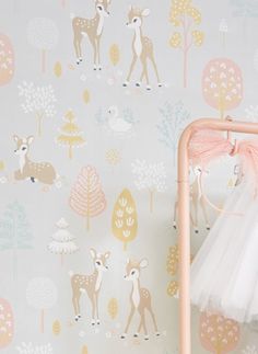 a baby crib next to a wall with deer and trees on it