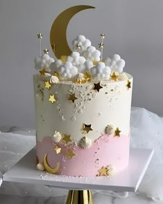 a white and pink cake with gold stars on top