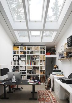 a home office with skylights above the desk and bookshelves on the wall