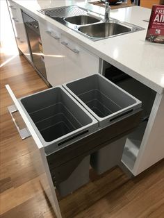 an open drawer in the middle of a kitchen counter with a sink and dishwasher