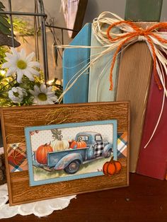 an old blue truck with pumpkins on the back is hanging from a wooden frame