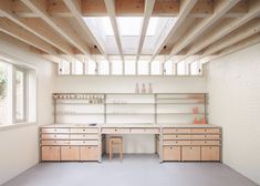 an empty room with shelves, desks and chairs in it's center area