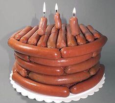 there is a cake made out of hot dogs on a plate with candles in the middle