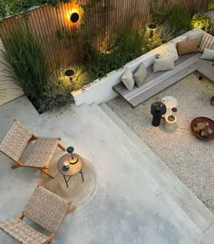 an aerial view of a patio with seating and table in the center, surrounded by greenery