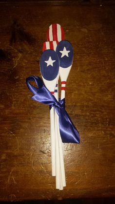 two red, white and blue plastic spoons with stars on them are tied together