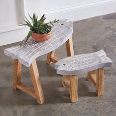 a small wooden bench with a potted plant sitting on it's back end