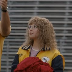 a woman with curly hair and glasses is holding a frisbee in her hand