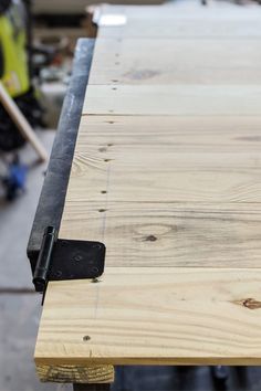 a close up of a wooden table with black metal brackets on the top and bottom