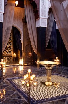 an elaborately decorated room with candles and curtains