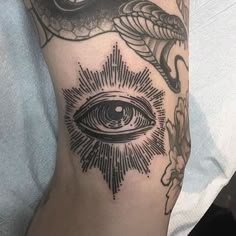 a close up of a person's arm with an all seeing tattoo on it