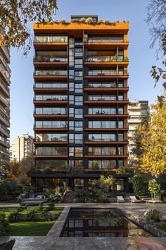 a tall building with lots of windows next to a pond