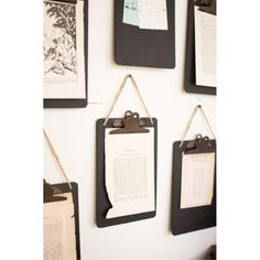 several pieces of paper hanging on a wall with clipboards attached to the side of it