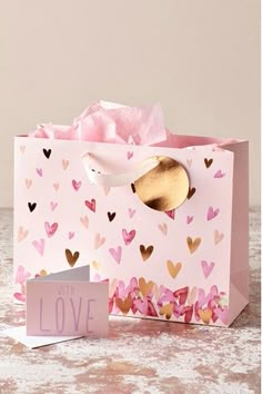 a pink gift bag with hearts on it