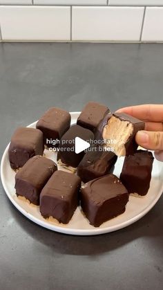 a person holding a plate with chocolates on it and peanut butter in the middle