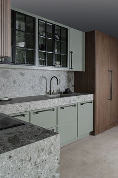 a kitchen with marble counter tops and wooden cabinets