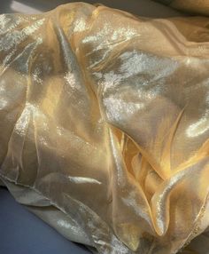 a shiny gold cloth is laying on a blue surface