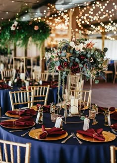 the tables are set with gold chargers and blue linens for an elegant wedding reception