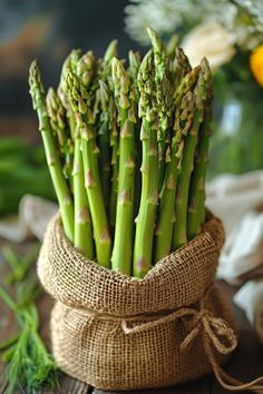 Bundle of fresh asparagus stalks in a burlap sack standing on a rustic wooden table. Easy Baked Recipes, Oven Baked Asparagus, Cook Asparagus