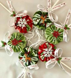 four lollipops decorated with green and red ribbons, snowflakes on them