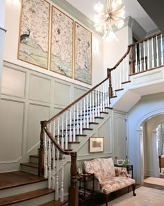 a living room filled with furniture next to a stair case and painting on the wall