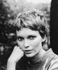 an old black and white photo of a woman with her hand on her chin looking at the camera