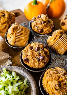 several muffins are sitting on a tray next to some vegetables and pumpkins