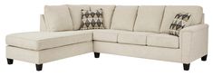 a white sectional couch with pillows on it