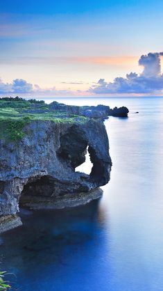 an image of the ocean and cliffs at sunset