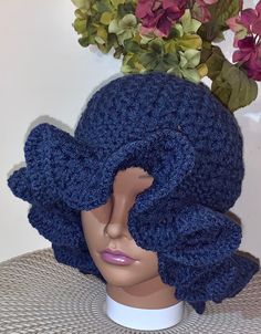 a crocheted blue hat on top of a mannequin's head