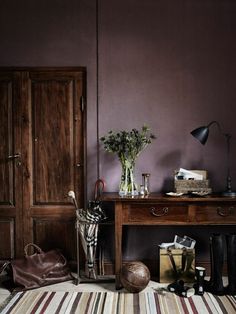 a room with purple walls and striped rug