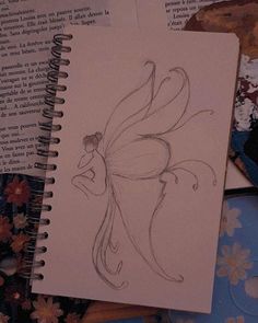 a drawing of a butterfly sitting on top of an open book next to some flowers