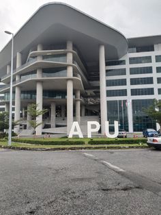 a large building with the word apu painted on it's side in front of an empty parking lot