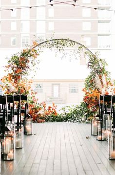 an outdoor ceremony setup with candles and flowers on the floor, surrounded by greenery