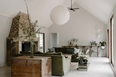 a living room filled with furniture and a fire place next to a brick wall on top of a white floor