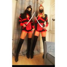 two women dressed in costumes with swords standing next to each other